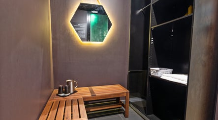 Relaxing seating area at The Savoy Hotel - V Hotel Spa, Melbourne, VIC, AU with mirror and wooden bench.