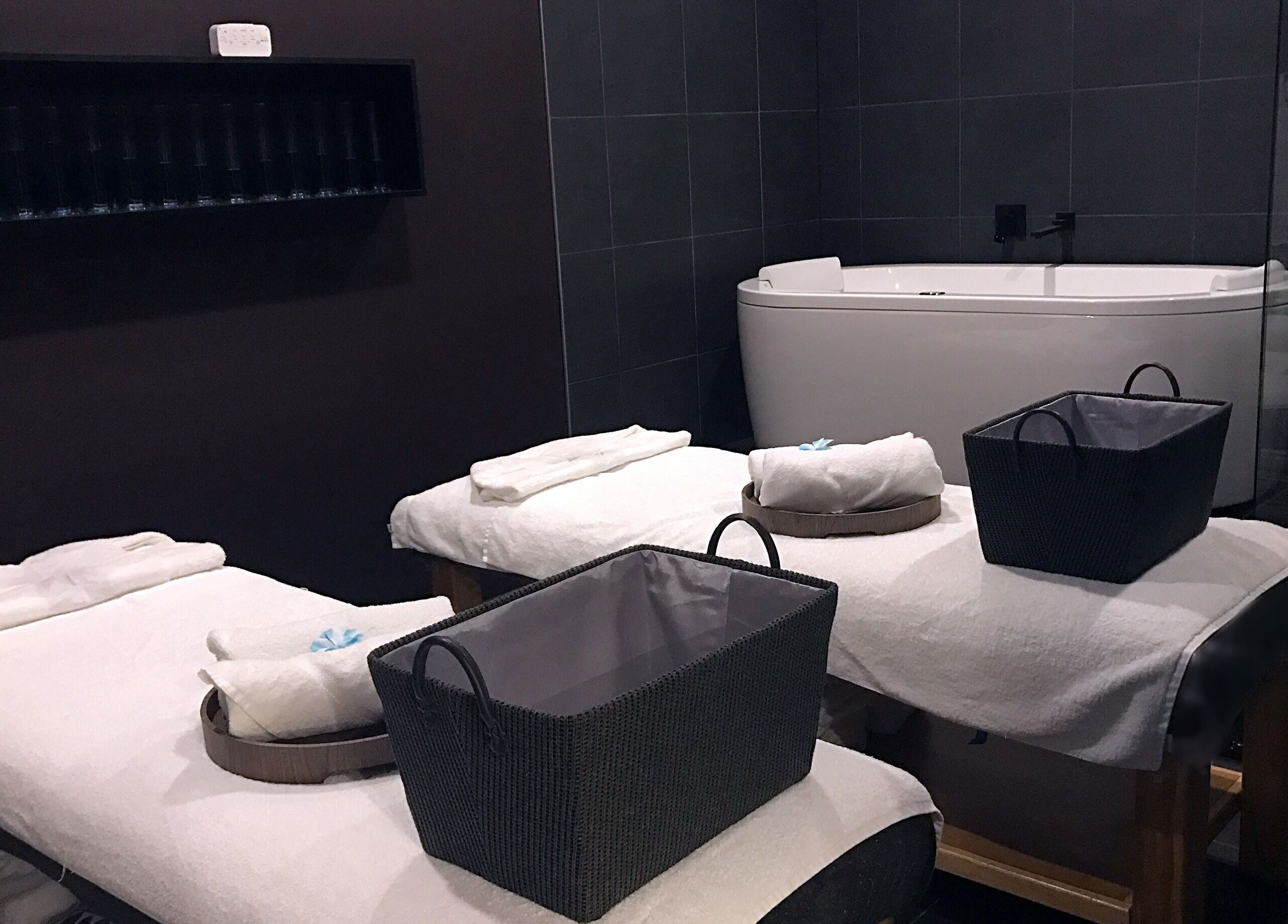 Luxurious spa room at The Savoy Hotel - V Hotel Spa, Melbourne, VIC, AU, featuring massage tables and bathtub.