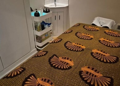 Cozy treatment room at Ayma Therapeutics, London, England, GB with patterned massage bed and soothing decor.