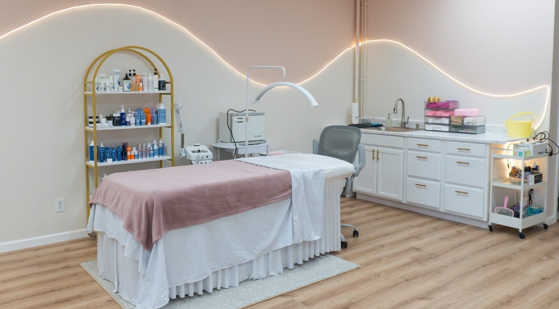 A cozy treatment room at CaiteBeauty, Shelton, Connecticut, US with a massage bed and beauty products.