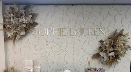 Interior wall with floral decor and Sophie Lauren Studios sign in Derby, England, GB.