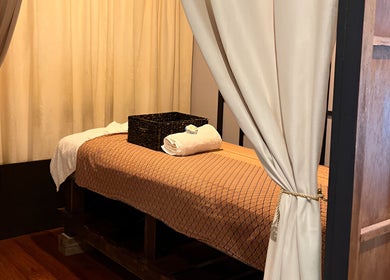 Peaceful massage room at Siam Botanical Thai Massage, Melbourne, Victoria, AU, with elegant curtains and a cozy bed.