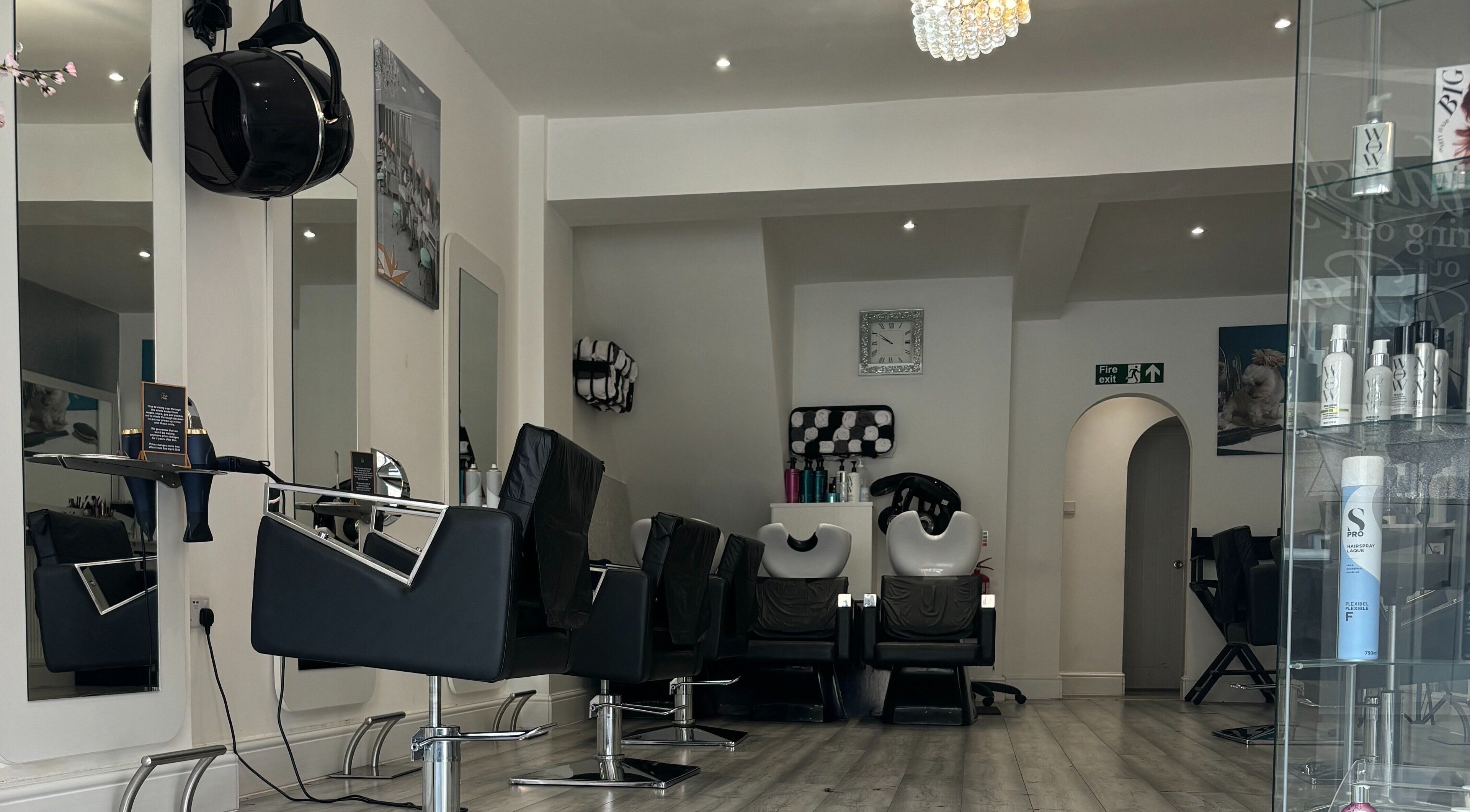 Modern interior of We Love Hair in Ellesmere Port, England, GB featuring stylish salon chairs and mirrors.