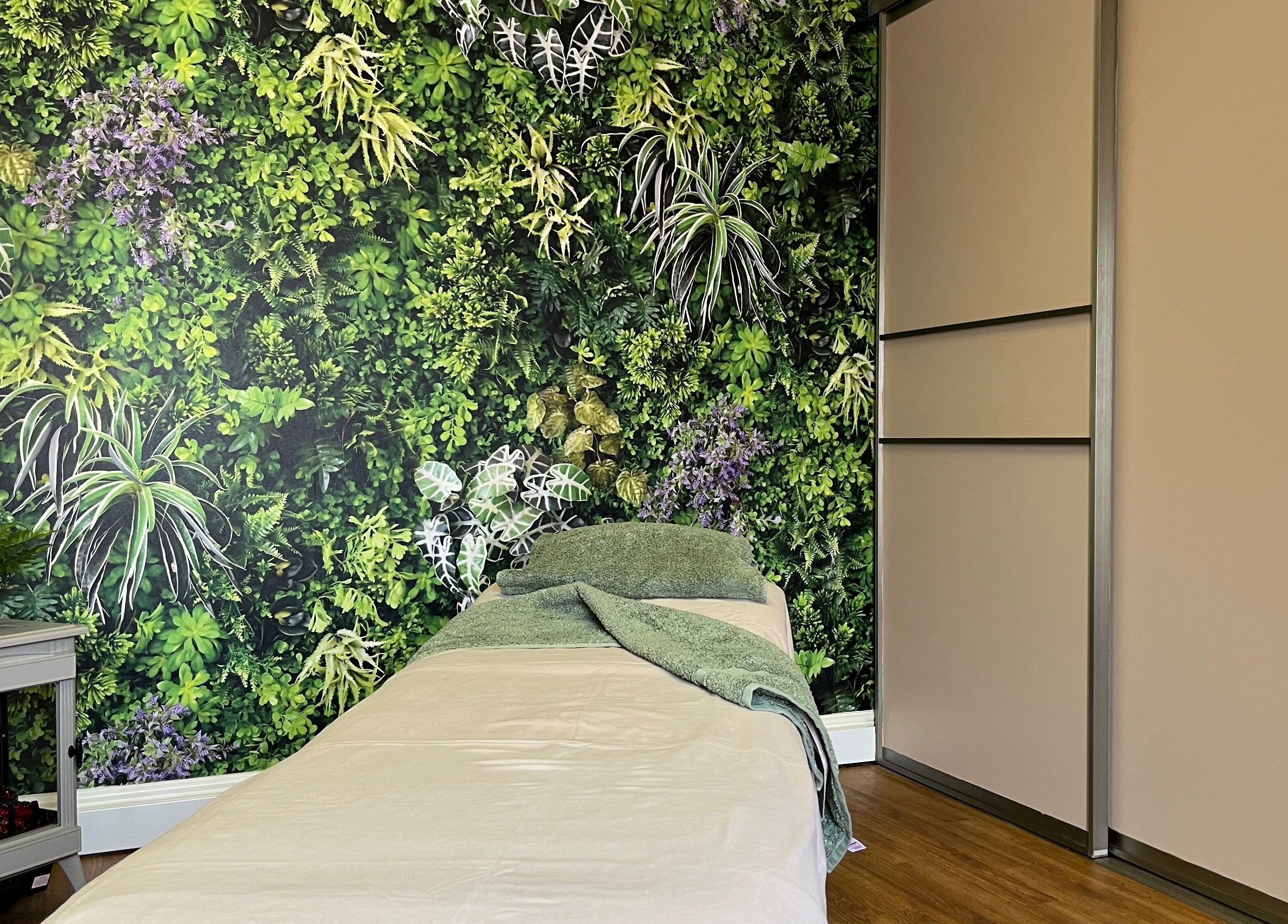 Tranquil therapy room at Fern Bodyworks in Hextable, England featuring lush greenery backdrop.