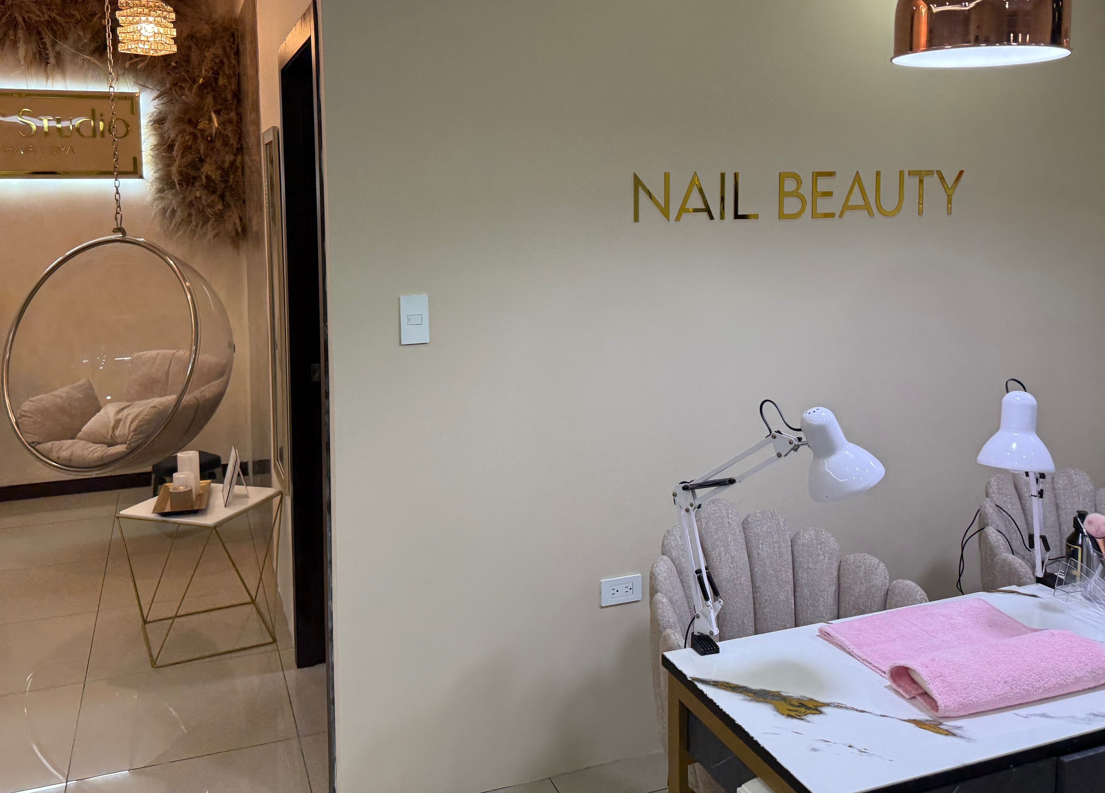 Interior de Twelve Studio en Quito, Pichincha, EC, mostrando zona de belleza de uñas y silla colgante.