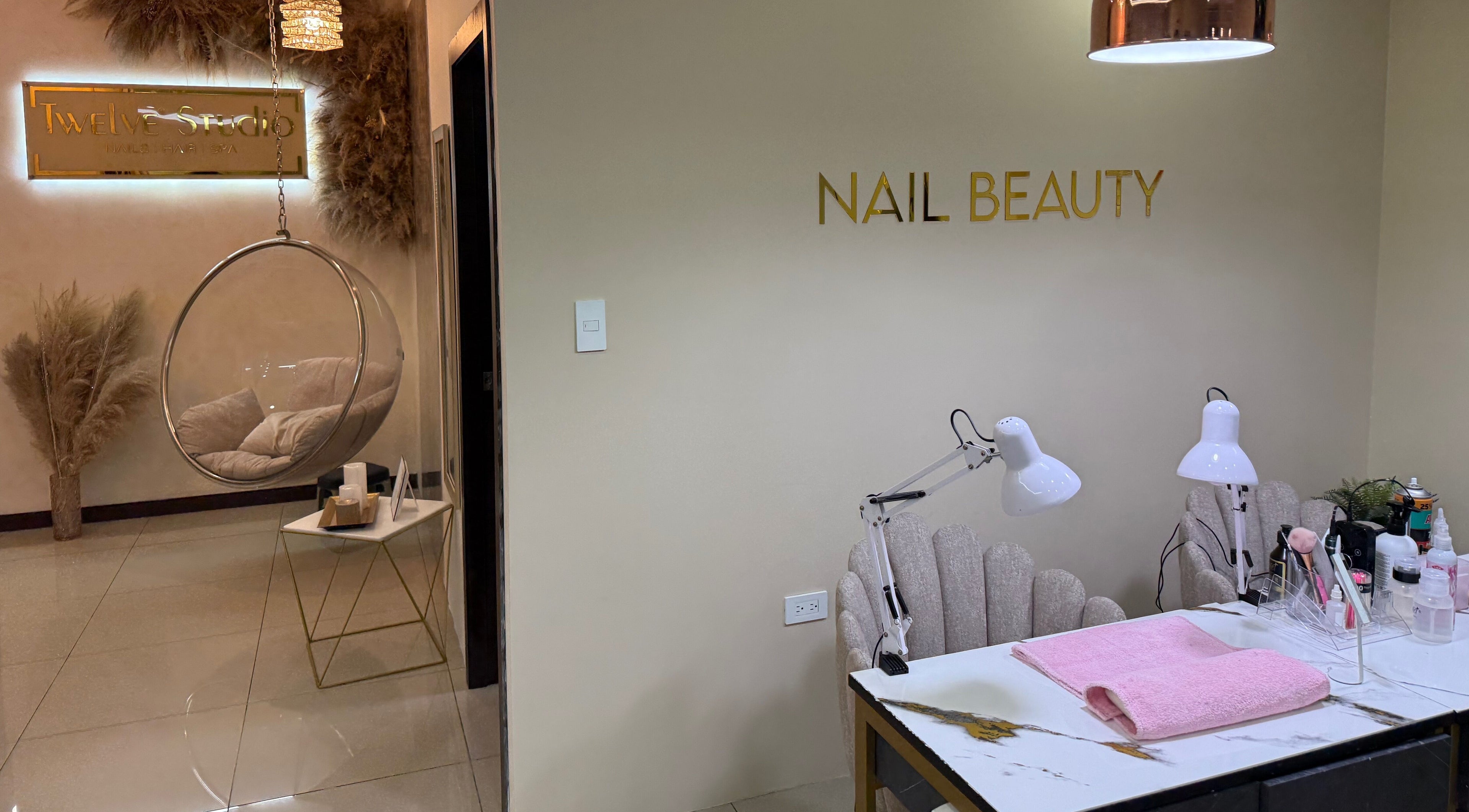 Interior de Twelve Studio en Quito, Pichincha, EC, mostrando zona de belleza de uñas y silla colgante.