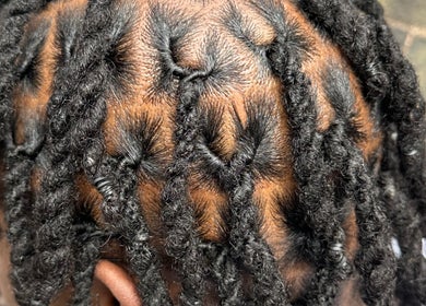Close-up of detailed braids at DiamzTouch in Birmingham, England. Neatly twisted locs.