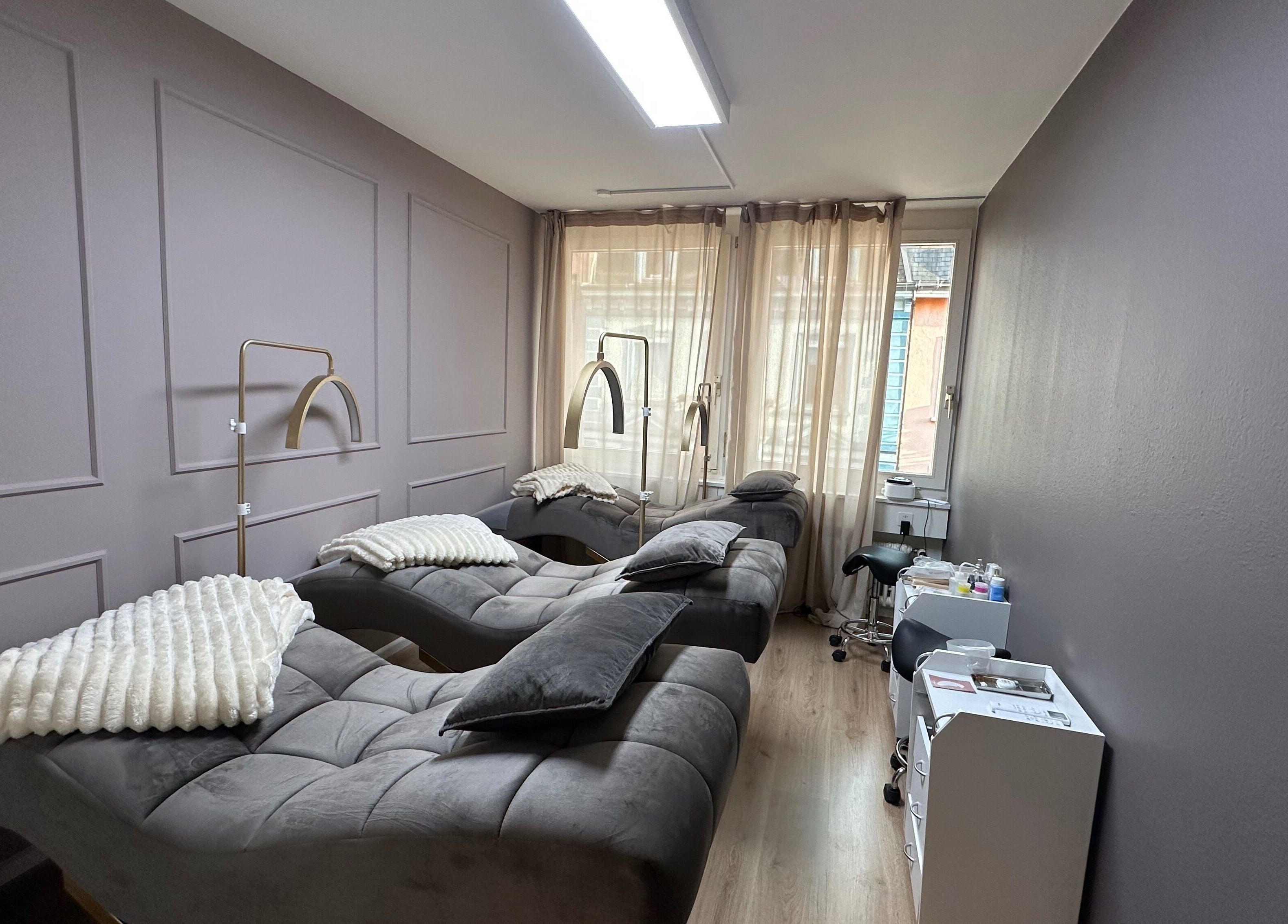 Modernes Interieur bei Swiss Beauty Nails Basel, Basel, Basel-stadt, CH mit stilvollen Liegen und sanfter Beleuchtung.