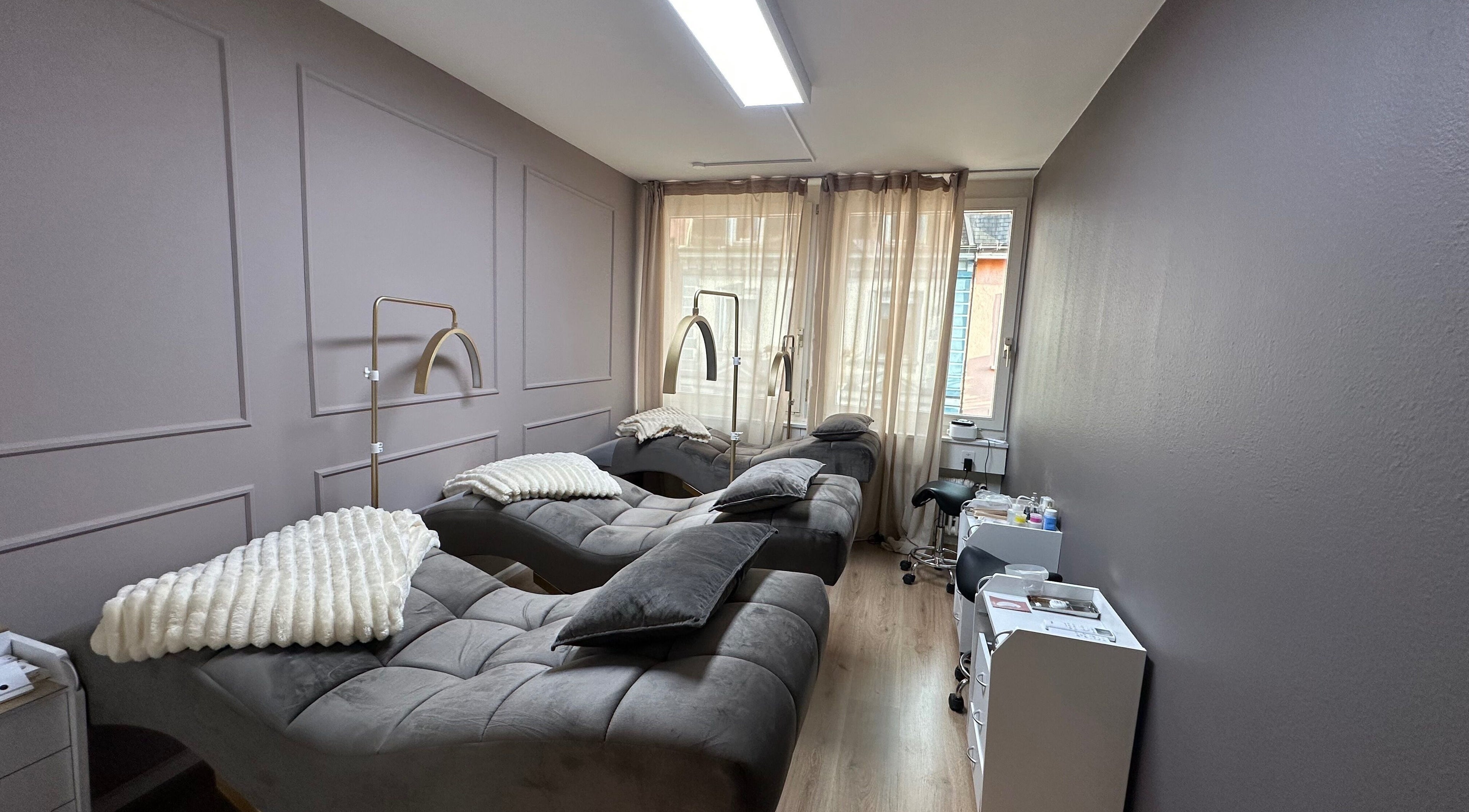 Modernes Interieur bei Swiss Beauty Nails Basel, Basel, Basel-stadt, CH mit stilvollen Liegen und sanfter Beleuchtung.