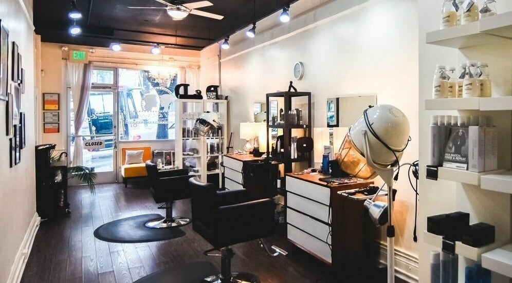 Interior of Dolled and Dapper Salon in San Francisco, California, US, showcasing stylish chairs and beauty products.
