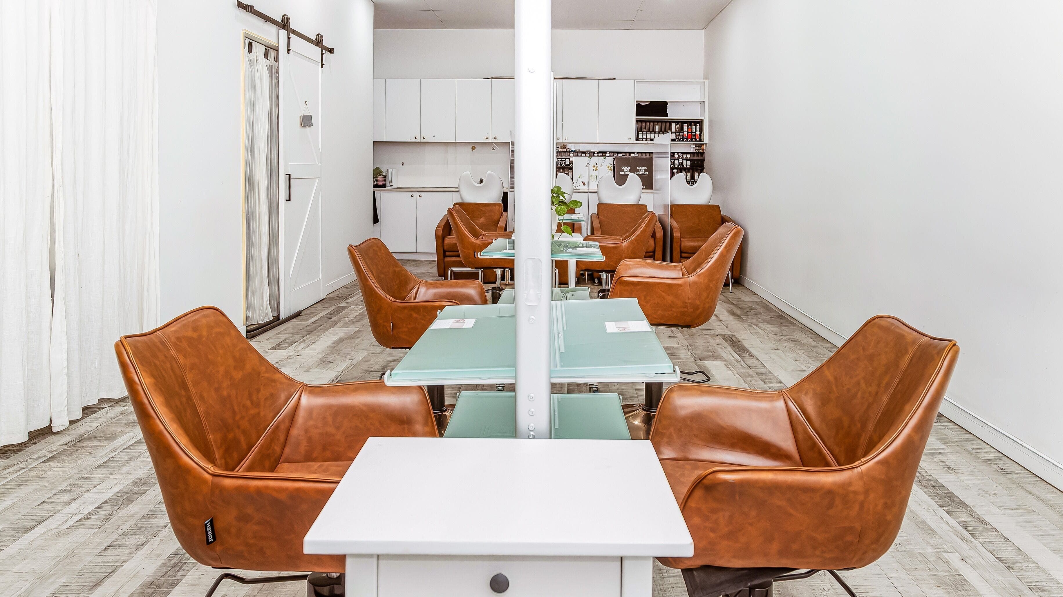 Chic interior of Elixir Hair & Beauty salon on Gold Coast, Queensland, AU featuring stylish leather chairs.