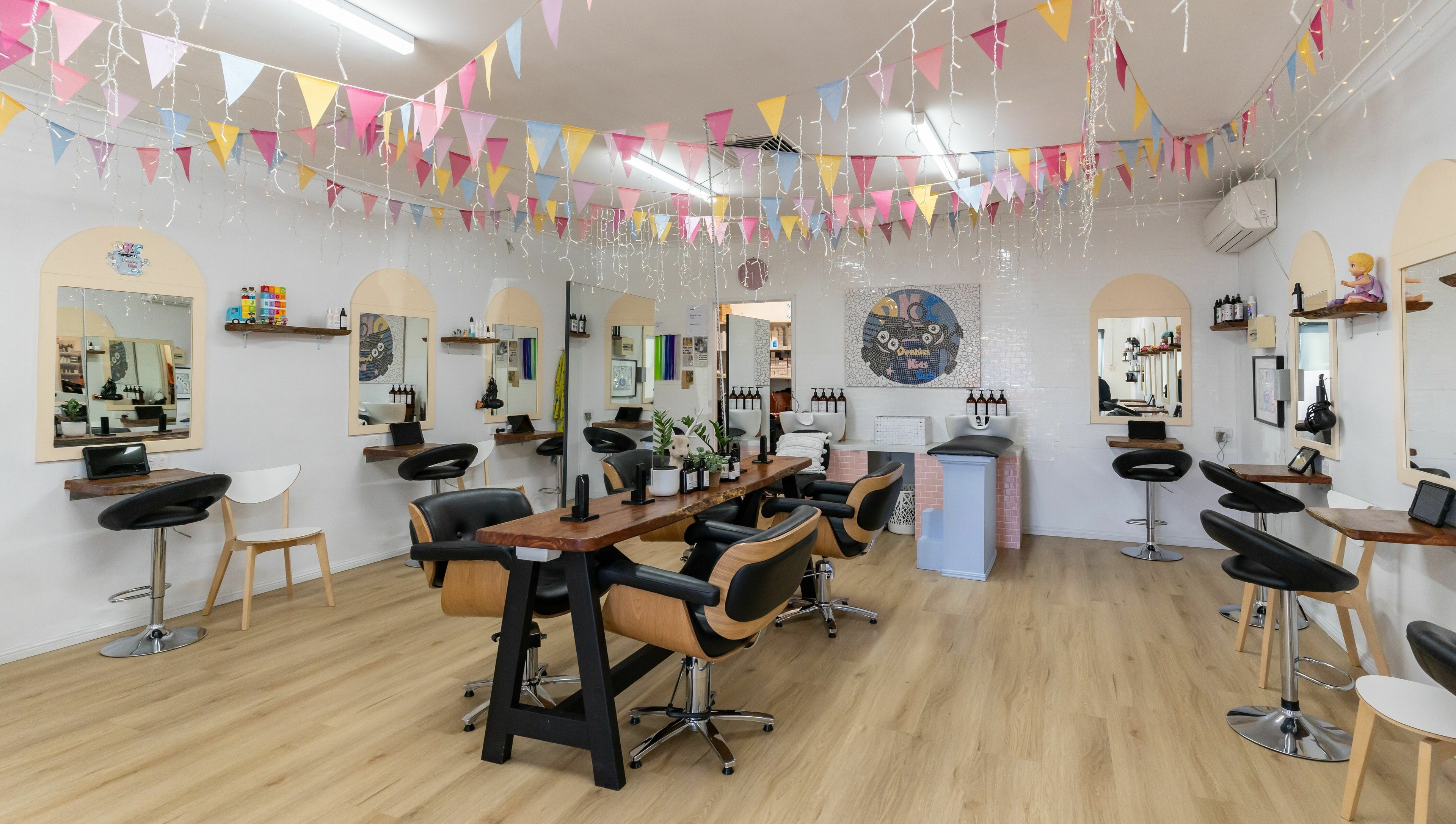 Stylish interior of Deanies Kids Cuts in Currimundi, Queensland, AU with festive decor and modern salon chairs.