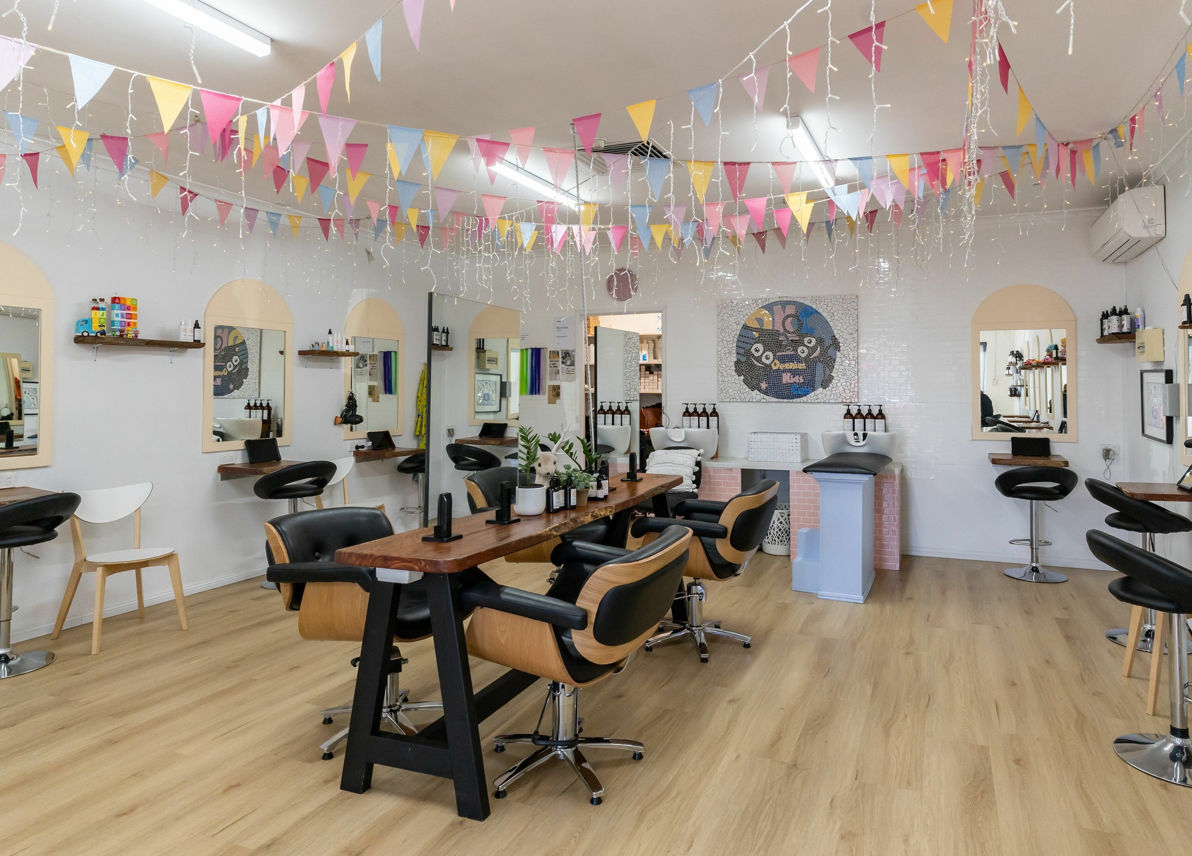 Stylish interior of Deanies Kids Cuts in Currimundi, Queensland, AU with festive decor and modern salon chairs.