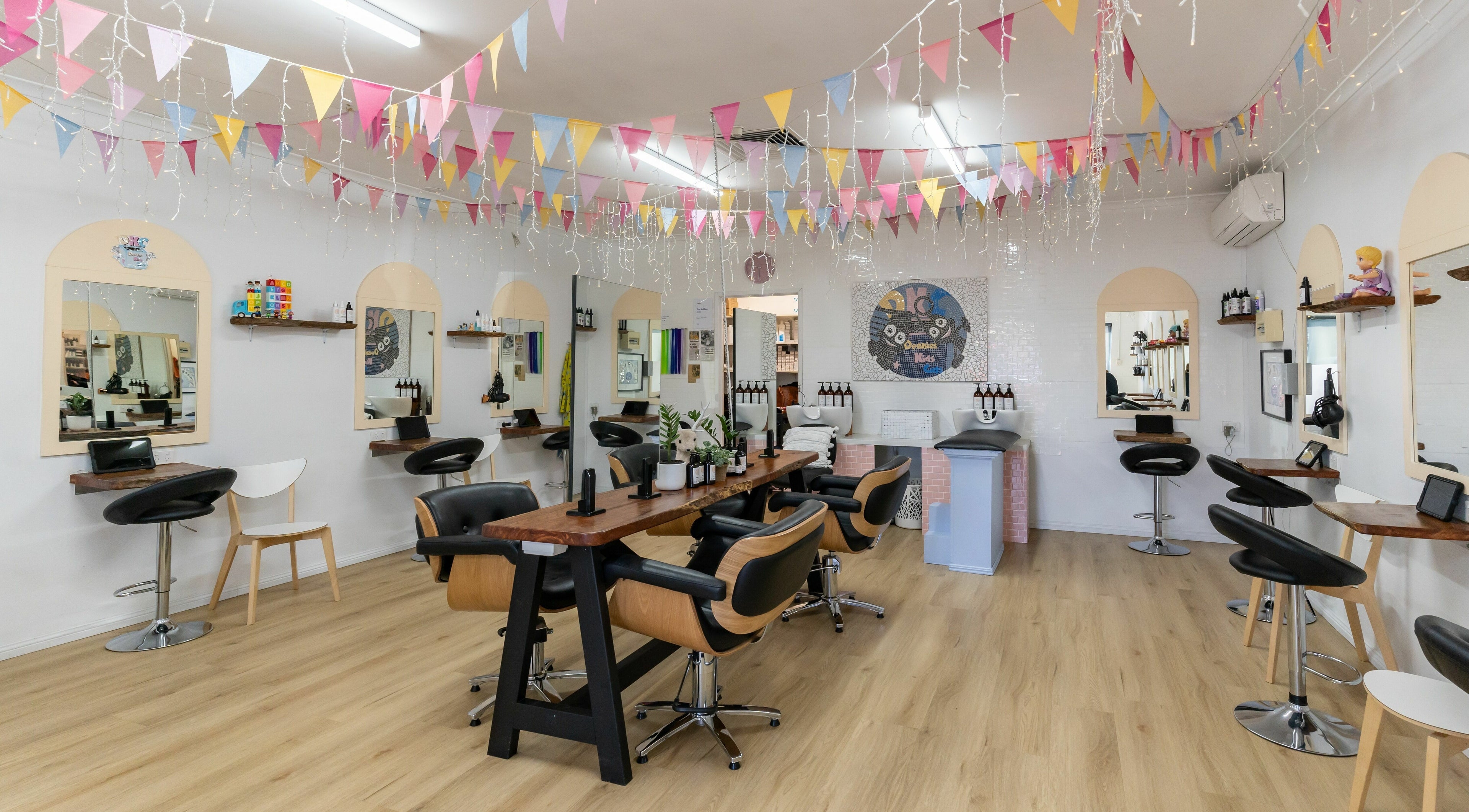 Stylish interior of Deanies Kids Cuts in Currimundi, Queensland, AU with festive decor and modern salon chairs.