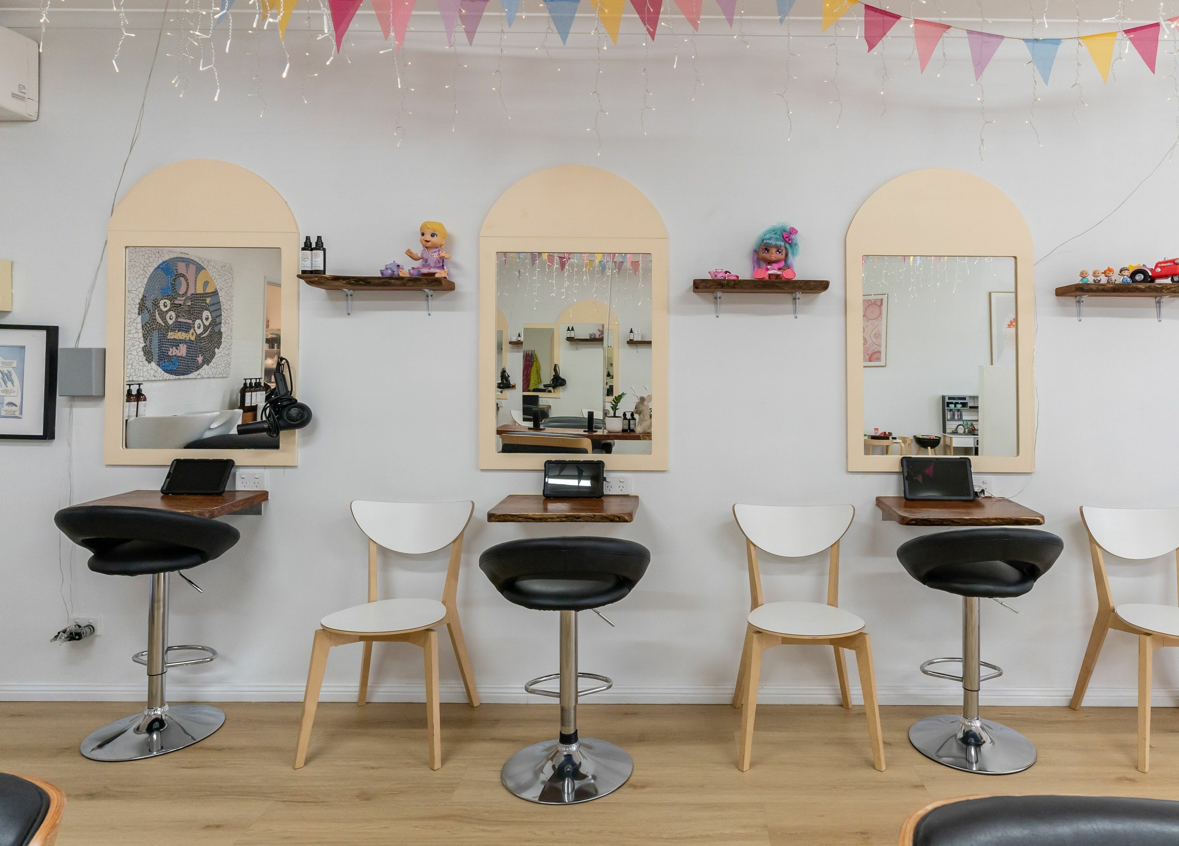 Interior view of Deanies Kids Cuts in Currimundi, Queensland, AU, featuring colorful decor and child-friendly seating.