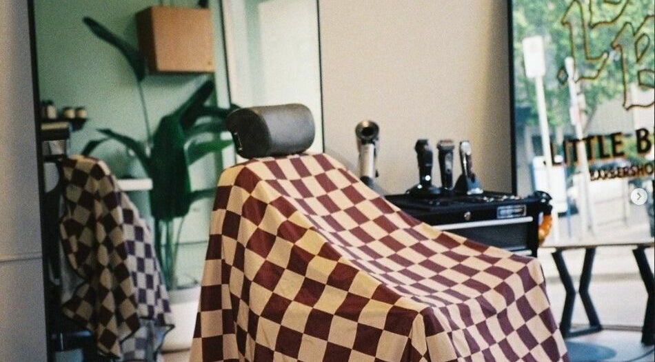 A classic barber chair with a checkered cover at Little Bear Barbershop, South Yarra, Victoria, AU.