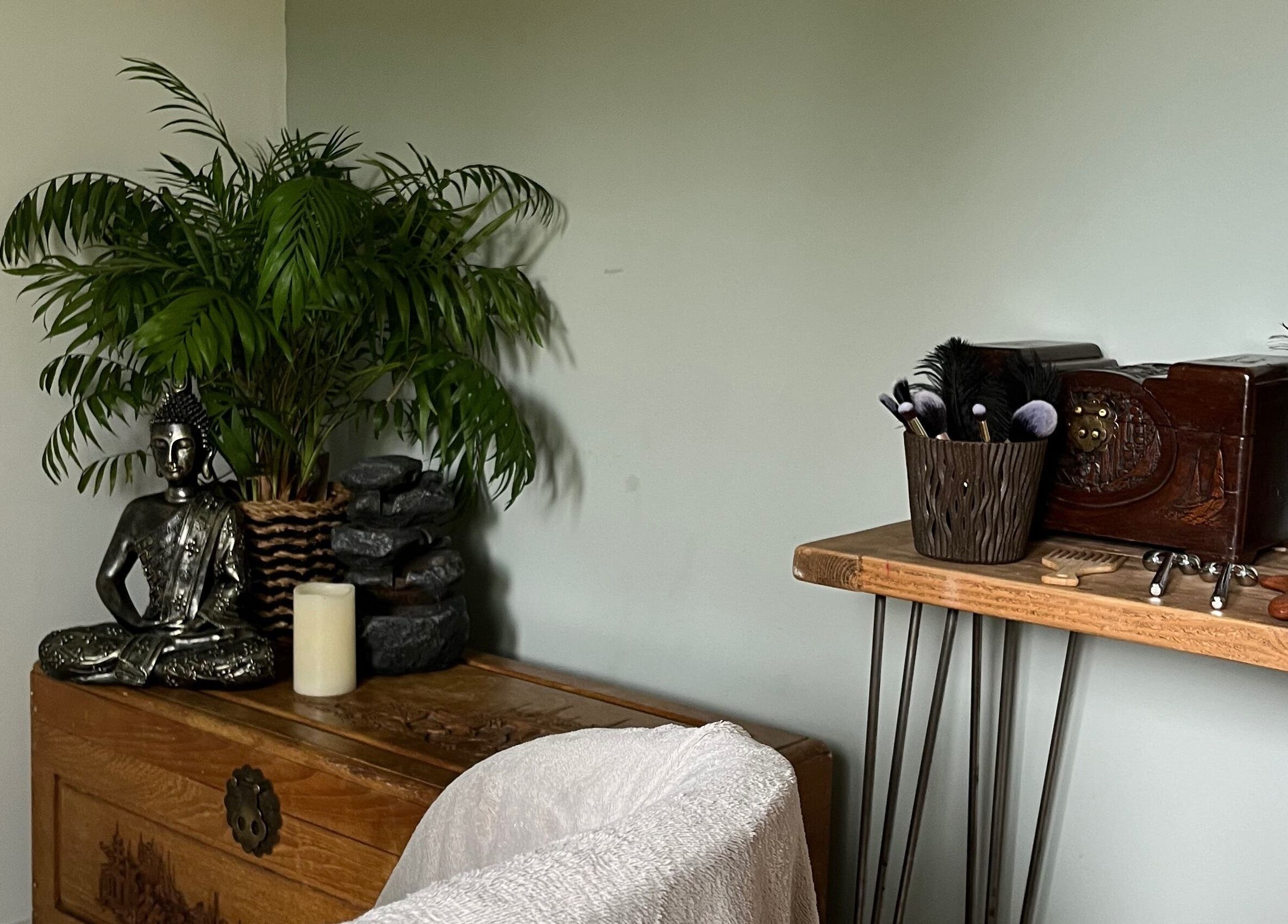 Serene interior of Jenny Lockyer Reflexology, Gosport, England with Buddha statue and wellness tools.