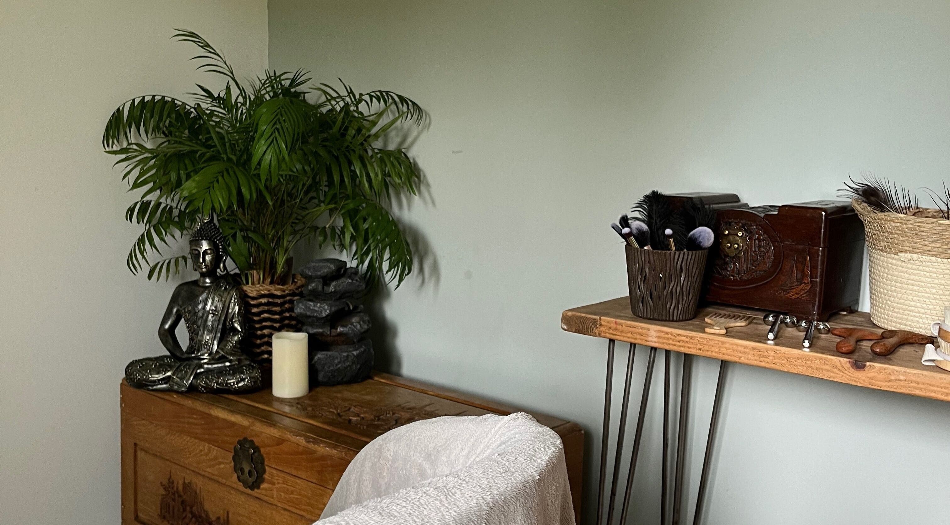 Serene interior of Jenny Lockyer Reflexology, Gosport, England with Buddha statue and wellness tools.