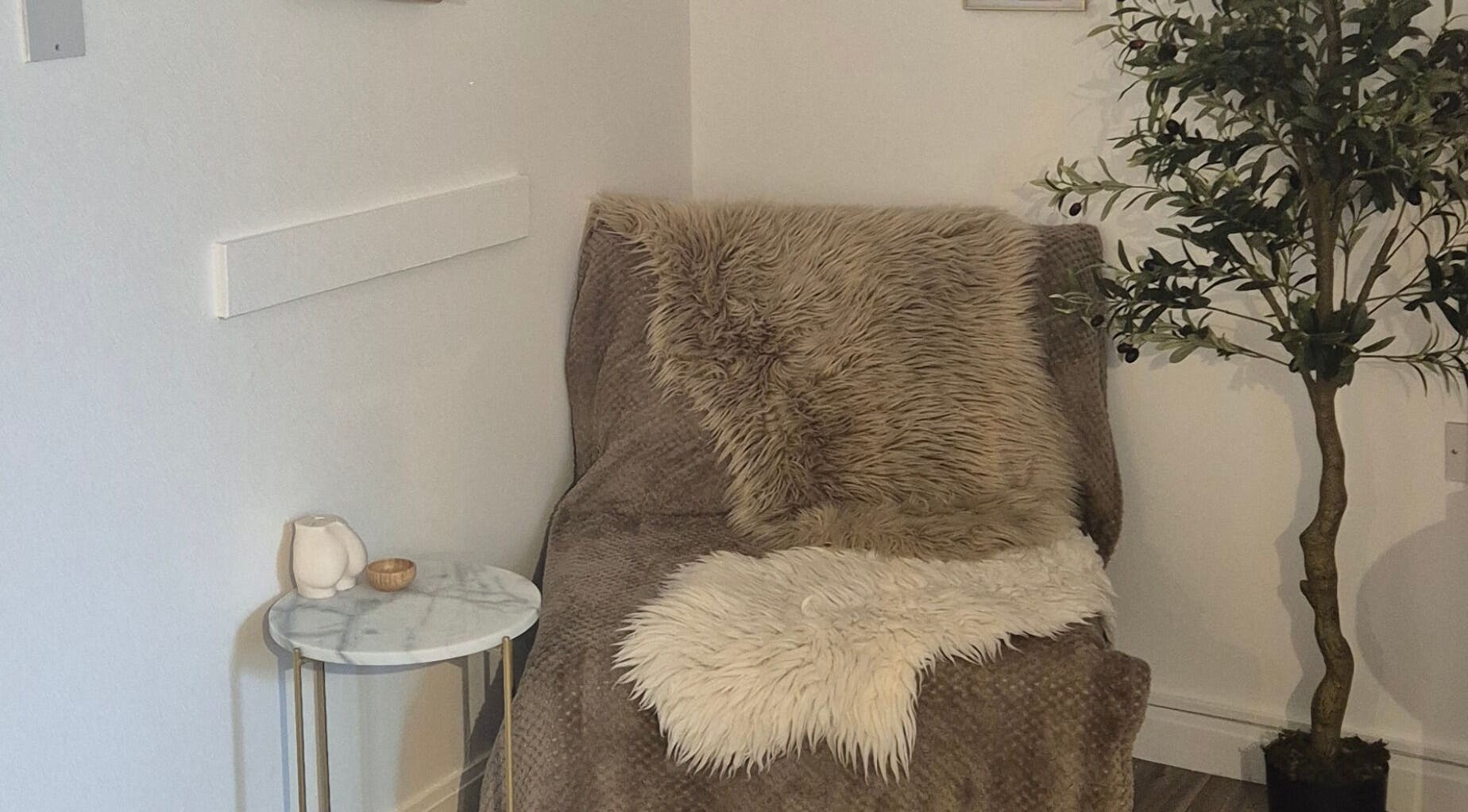 Cozy corner at The SKN Edit (Nude Studio) in Cockenzie Port Seton, Scotland, GB featuring soft furs and greenery.