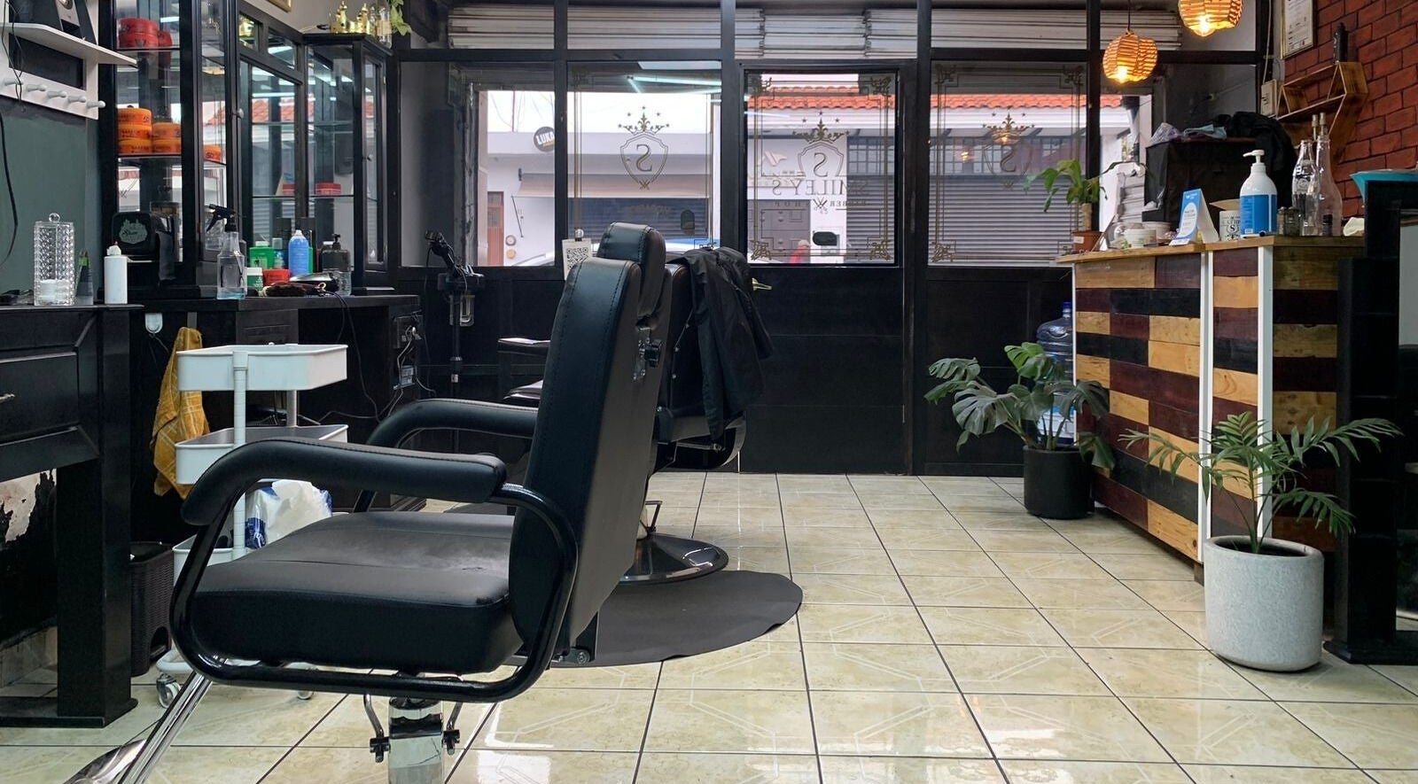 Interior de Smiley Barber Studio en Uruapan, Michoacán, MX, con asientos de barbería modernos y elegante decoración.