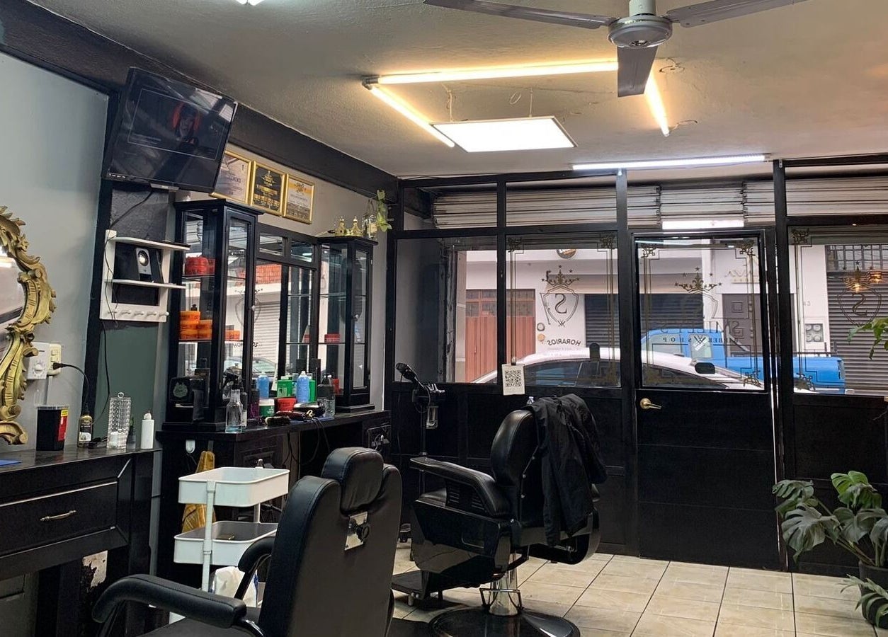 Interior elegante de Smiley Barber Studio en Uruapan, Michoacán, MX con sillas y espejos dorados.