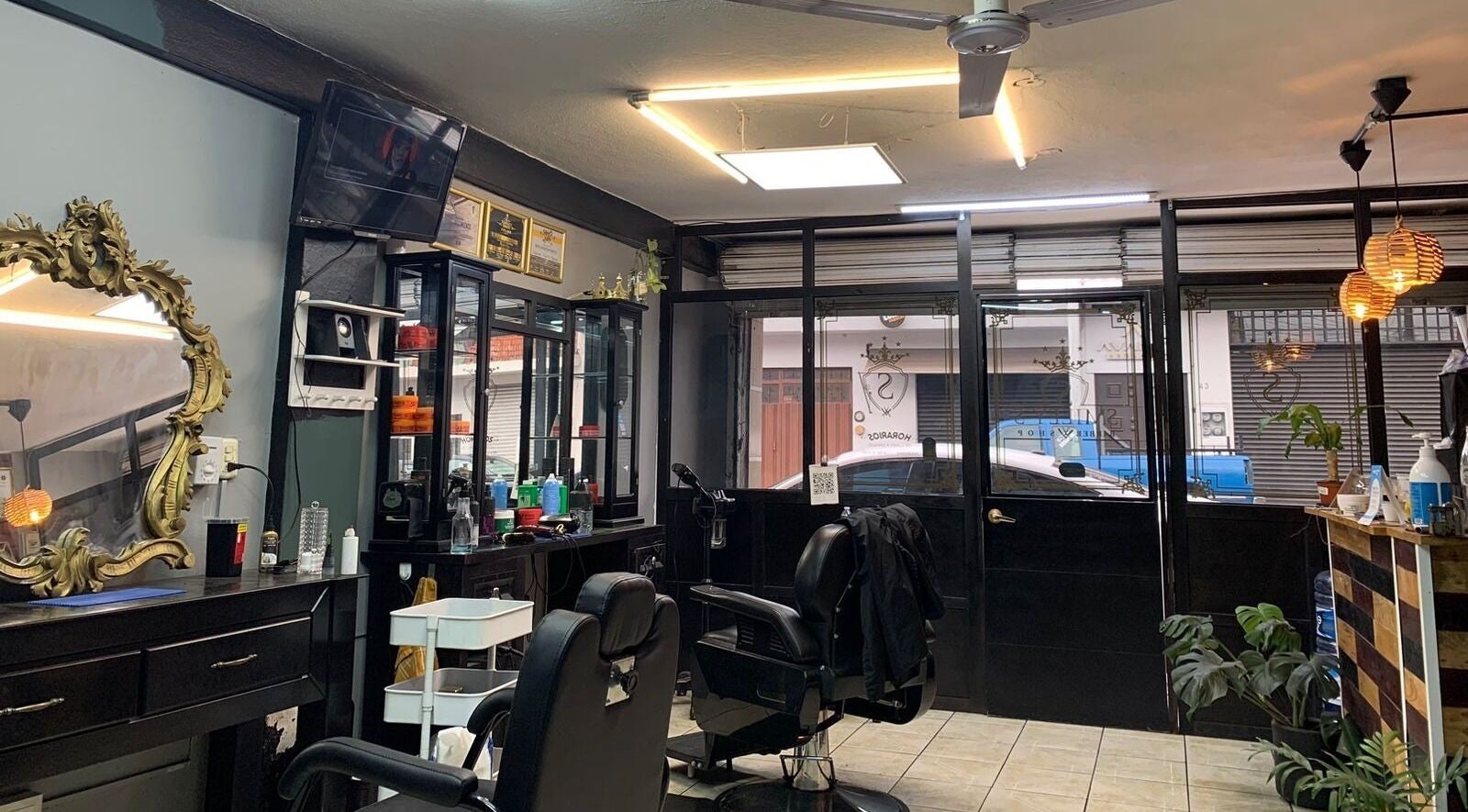 Interior elegante de Smiley Barber Studio en Uruapan, Michoacán, MX con sillas y espejos dorados.