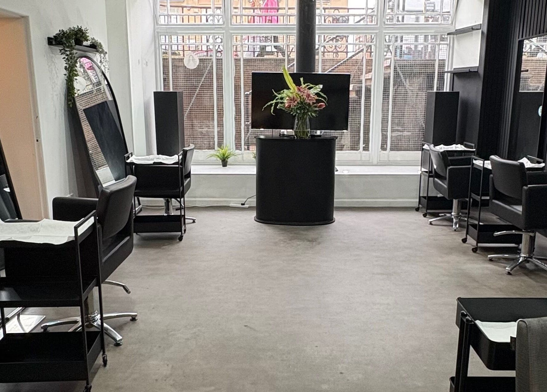 Elegant interior of The Collective Hair Co in Glasgow, Scotland, GB with modern styling stations and mirrors.