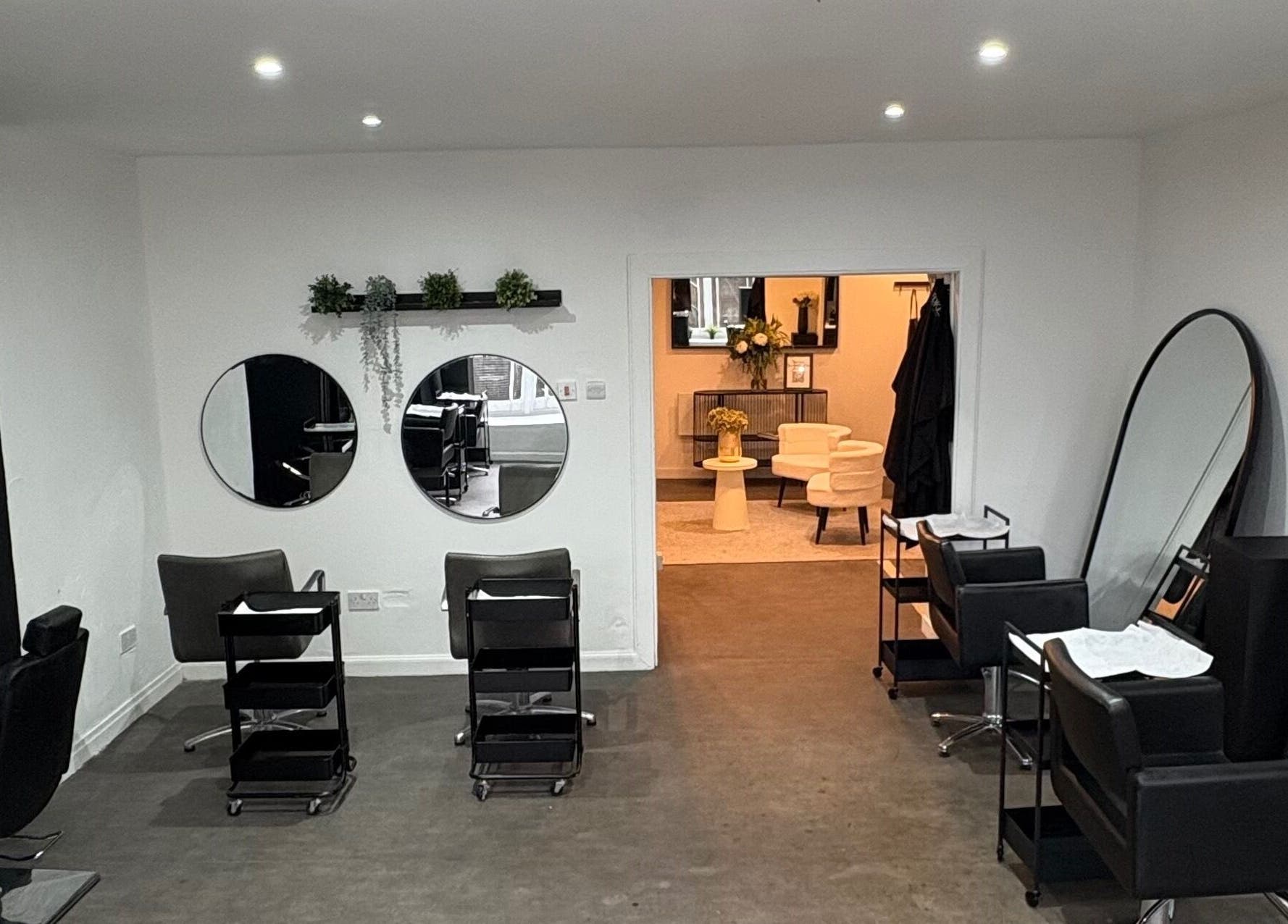Stylish salon interior at The Collective Hair Co, Glasgow, Scotland, GB featuring mirrors and salon chairs.