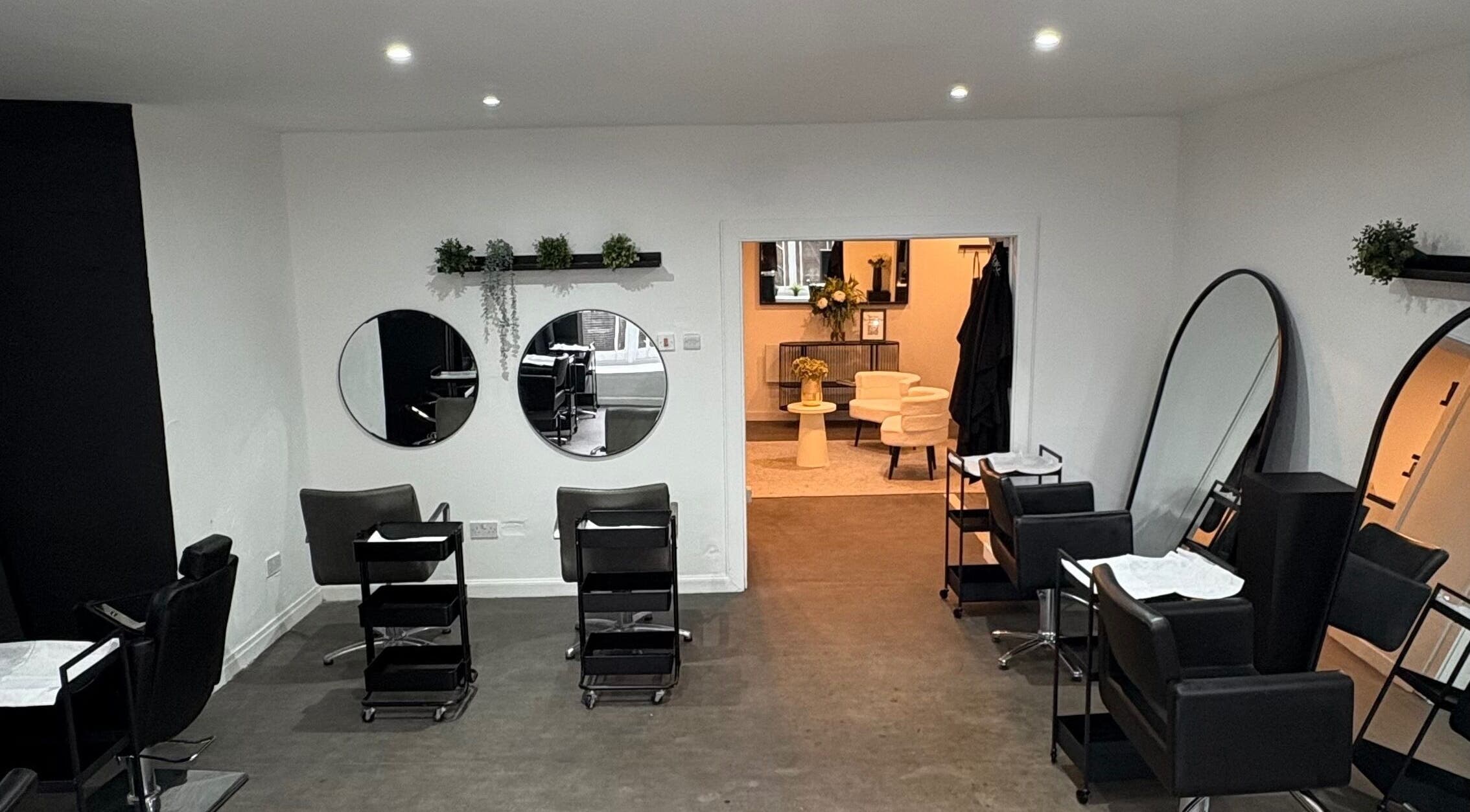 Stylish salon interior at The Collective Hair Co, Glasgow, Scotland, GB featuring mirrors and salon chairs.