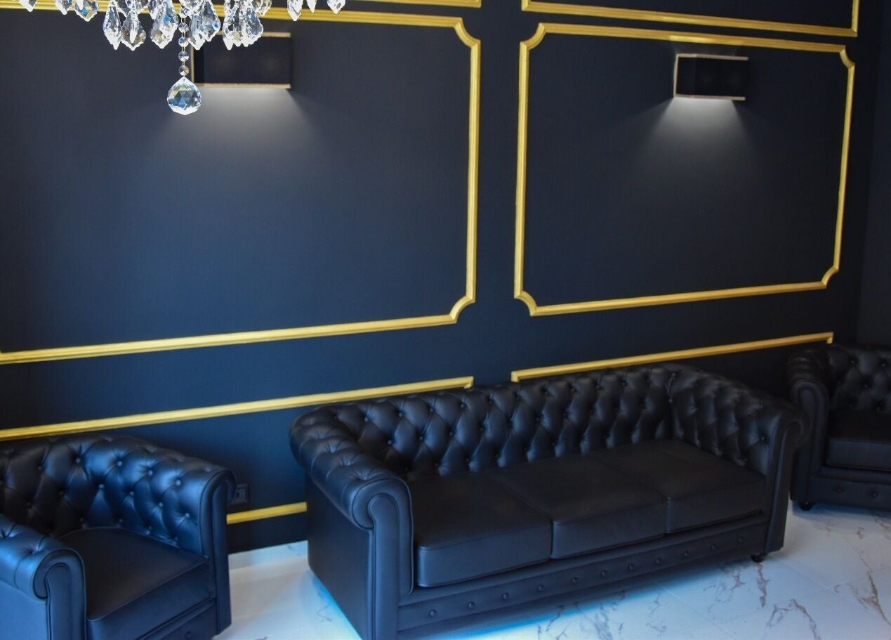Interno elegante di Blackout Concept, Terracina, Lazio, IT, con divani in pelle e decorazioni dorate.