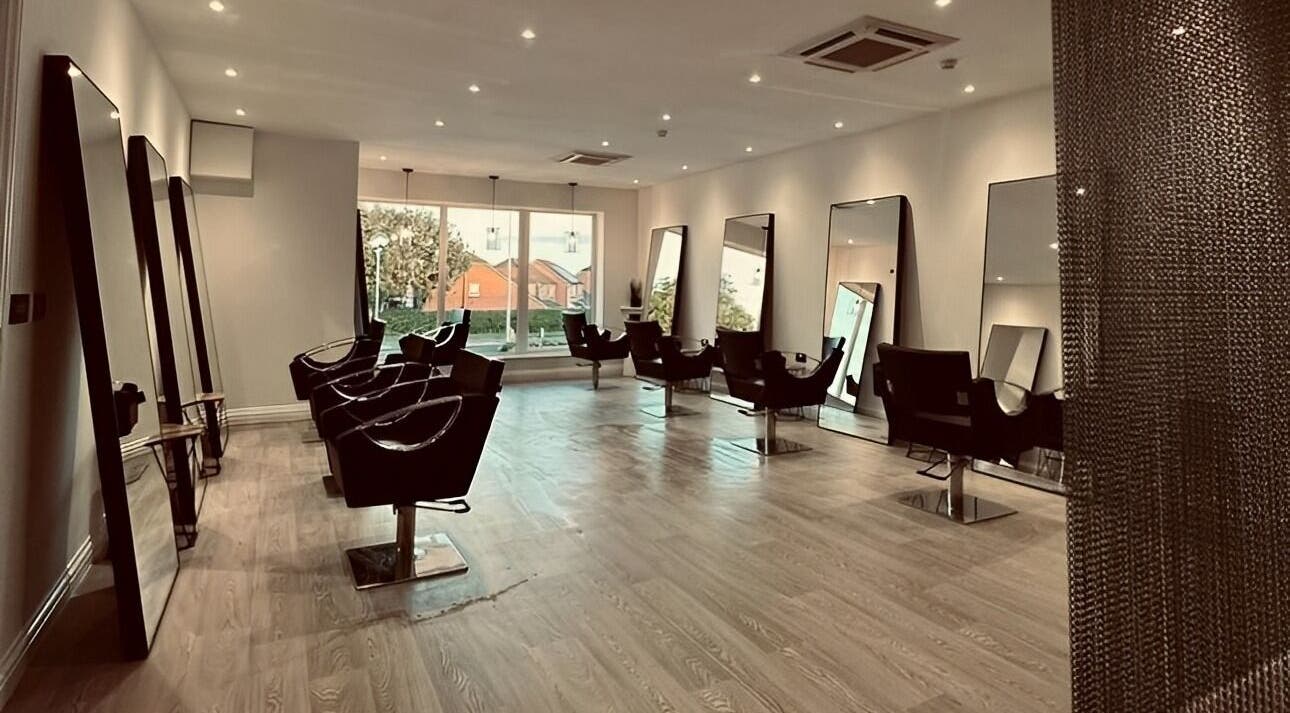 Modern salon interior at Rachel Dee - ATELIER, Preston, England, GB, featuring sleek styling chairs and large mirrors.