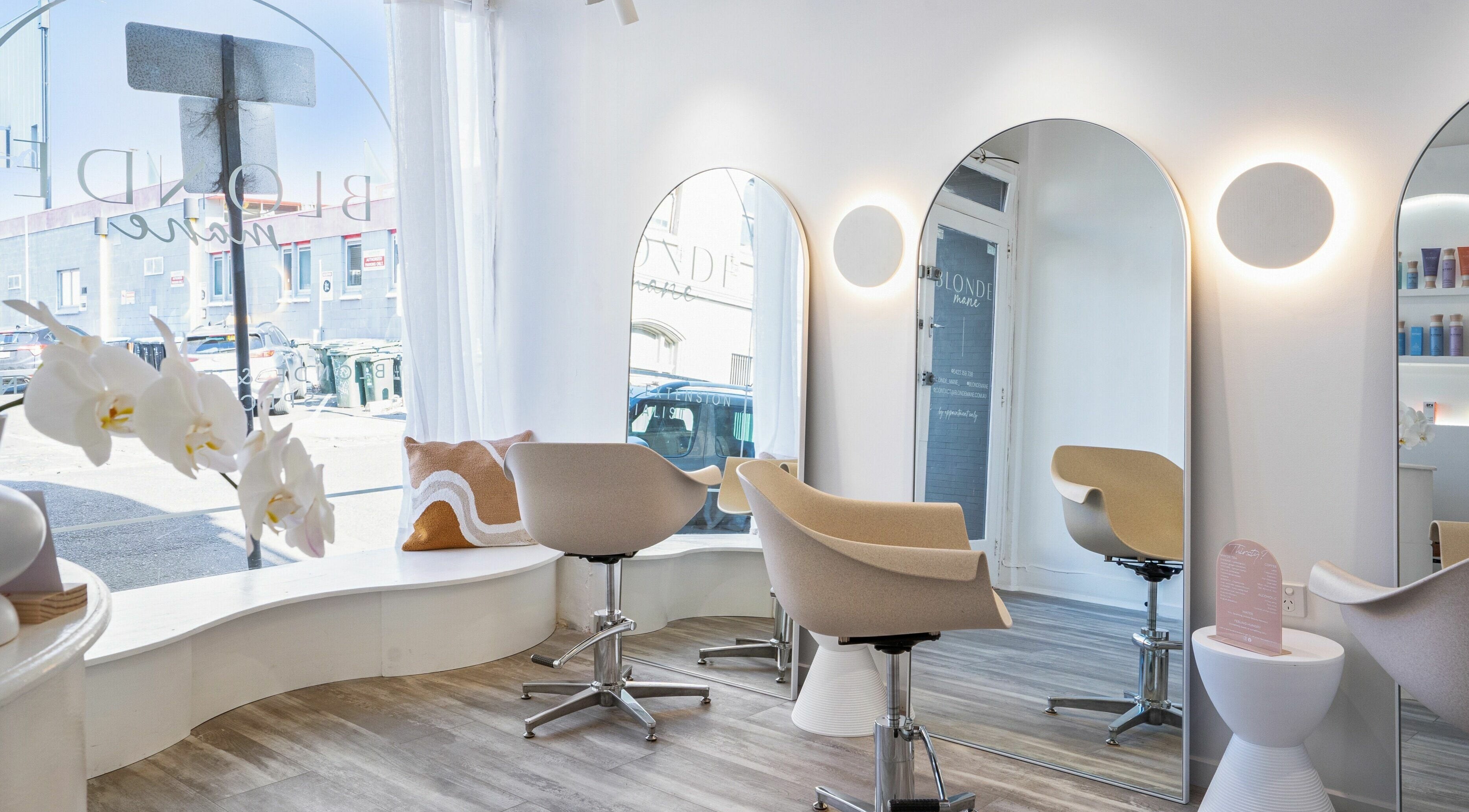 Bright and modern interior of Blonde Mane salon in Melbourne, Victoria, AU with stylish chairs and mirrors.