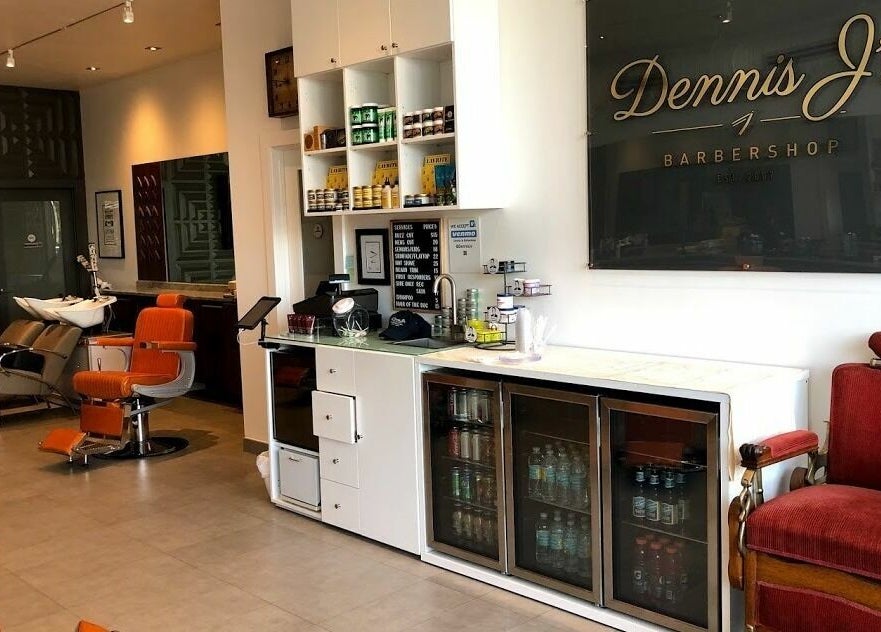 Modern interior of Dennis J's Barbershop in Fort Lauderdale, Florida, US showcasing seating and refreshments.