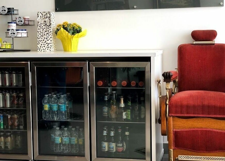Cozy refreshment area at Dennis J's Barbershop, Fort Lauderdale, Florida, US with vintage barber chair.