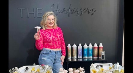Bright scene at THE Hairdressers, Lowestoft, England, featuring products and a smiling visitor.