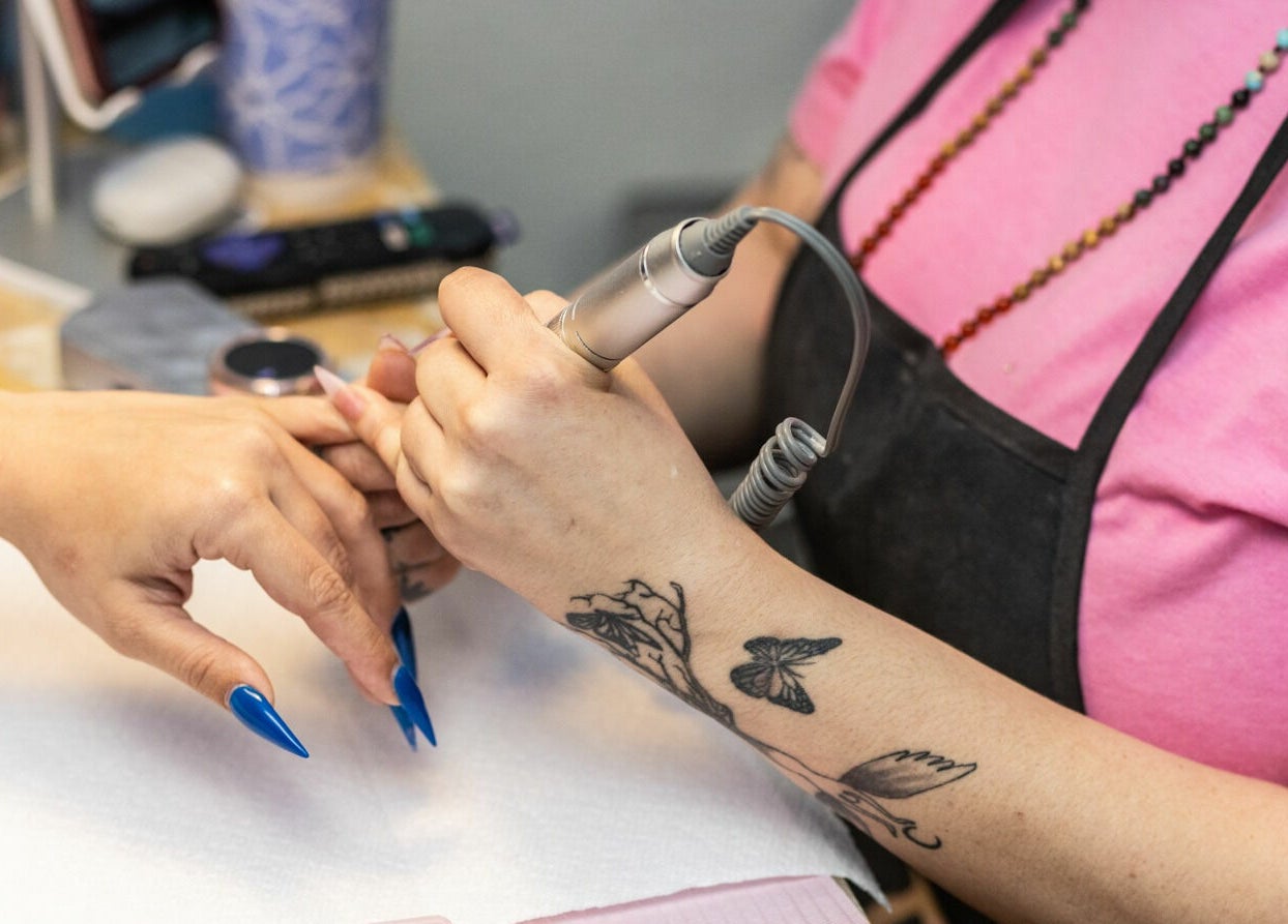 Nail technician working at Goddess Nails and Spa.LLC, West Allis, Wisconsin, US, performing a manicure.