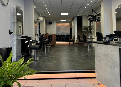 Interior of Edgars Hair Salon, West Bromwich, England, GB, showcasing stylish chairs and modern decor.
