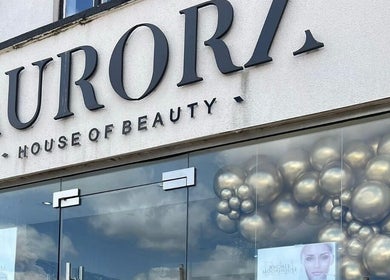 Front entrance of Aurora House of Beauty in Eccles, England, GB with elegant signage and balloons.