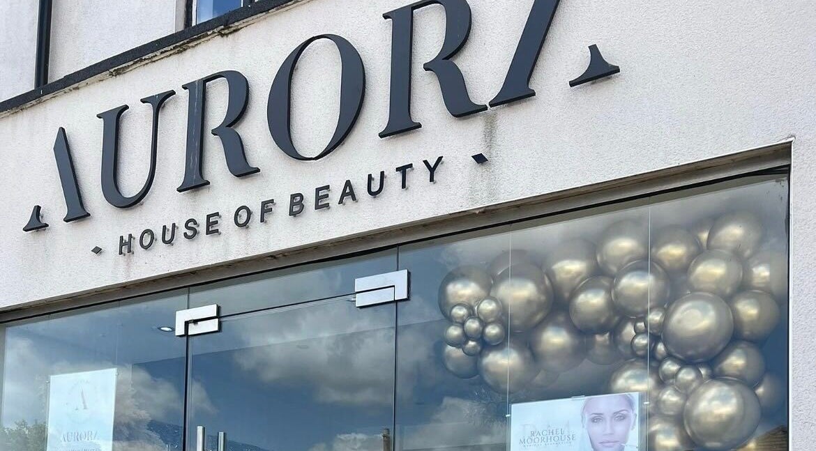 Front entrance of Aurora House of Beauty in Eccles, England, GB with elegant signage and balloons.