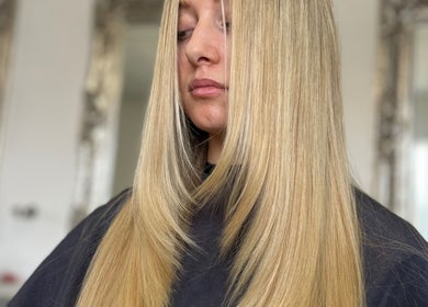 Smooth blonde hair treatment at Aurora House of Beauty, Eccles, England, GB. Salon mirrors in the background.