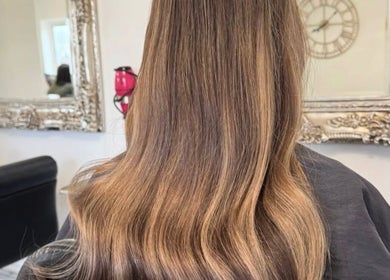 Beautifully styled hair at Aurora House of Beauty in Eccles, England, GB with ornate mirror backdrop.