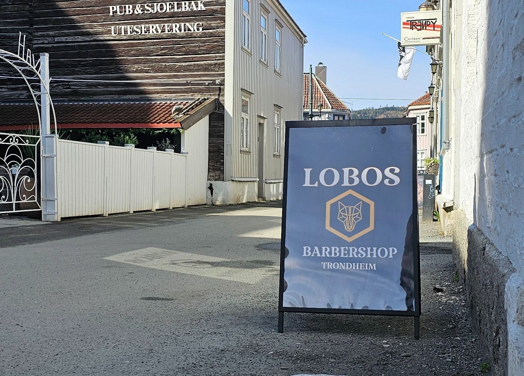 Veiskilt for Lobos Barbershop Trondheim, sentralt plassert i en gate i Trondheim, Trøndelag, NO.