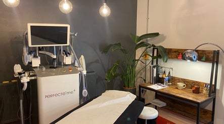 Modern treatment room at at1.AESTHETICS, Nottingham, England, GB with advanced aesthetic device and cozy decor.