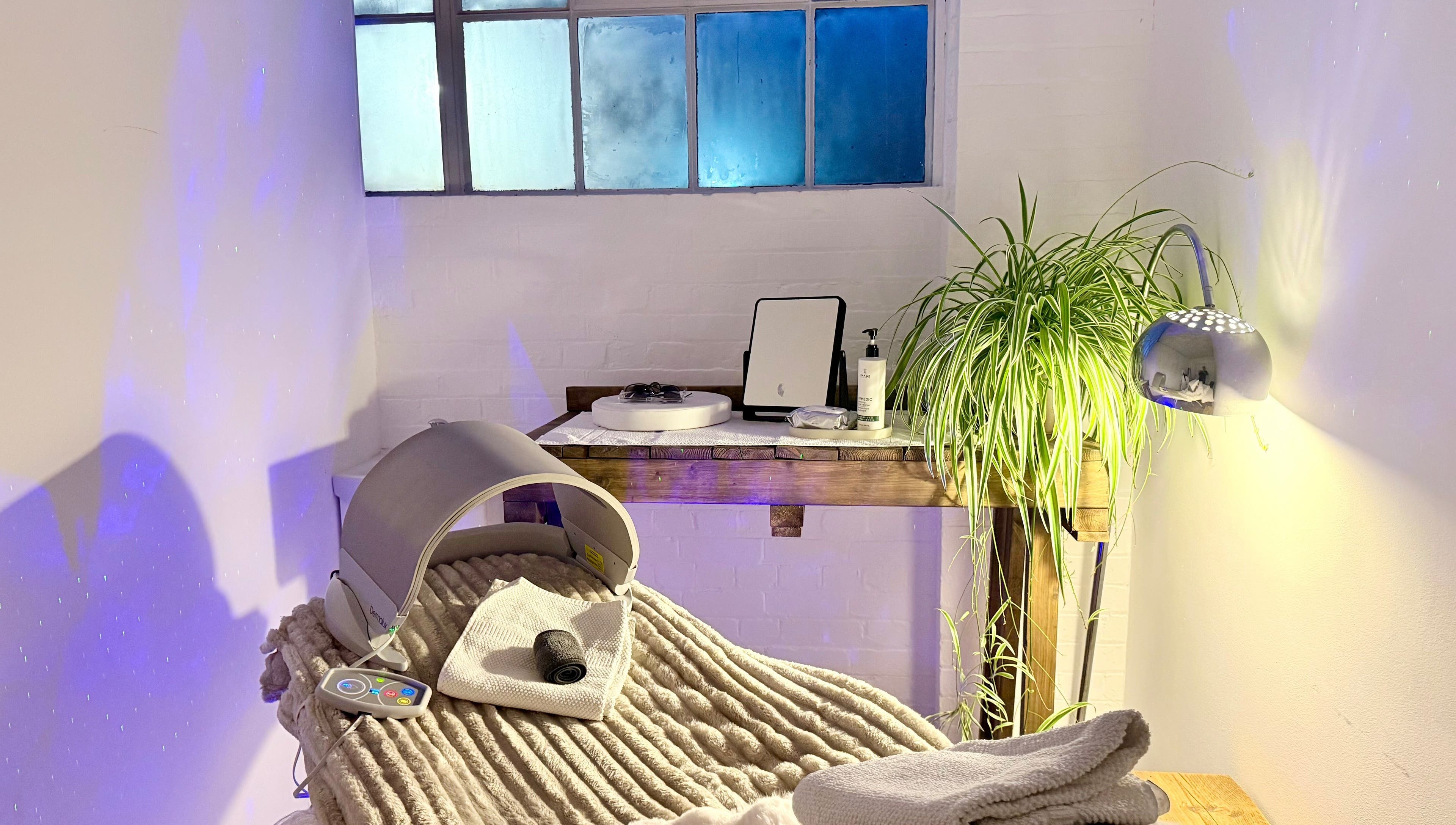 Tranquil wellness room at at1.AESTHETICS, Nottingham, England, GB, featuring plush chair and lush plant.