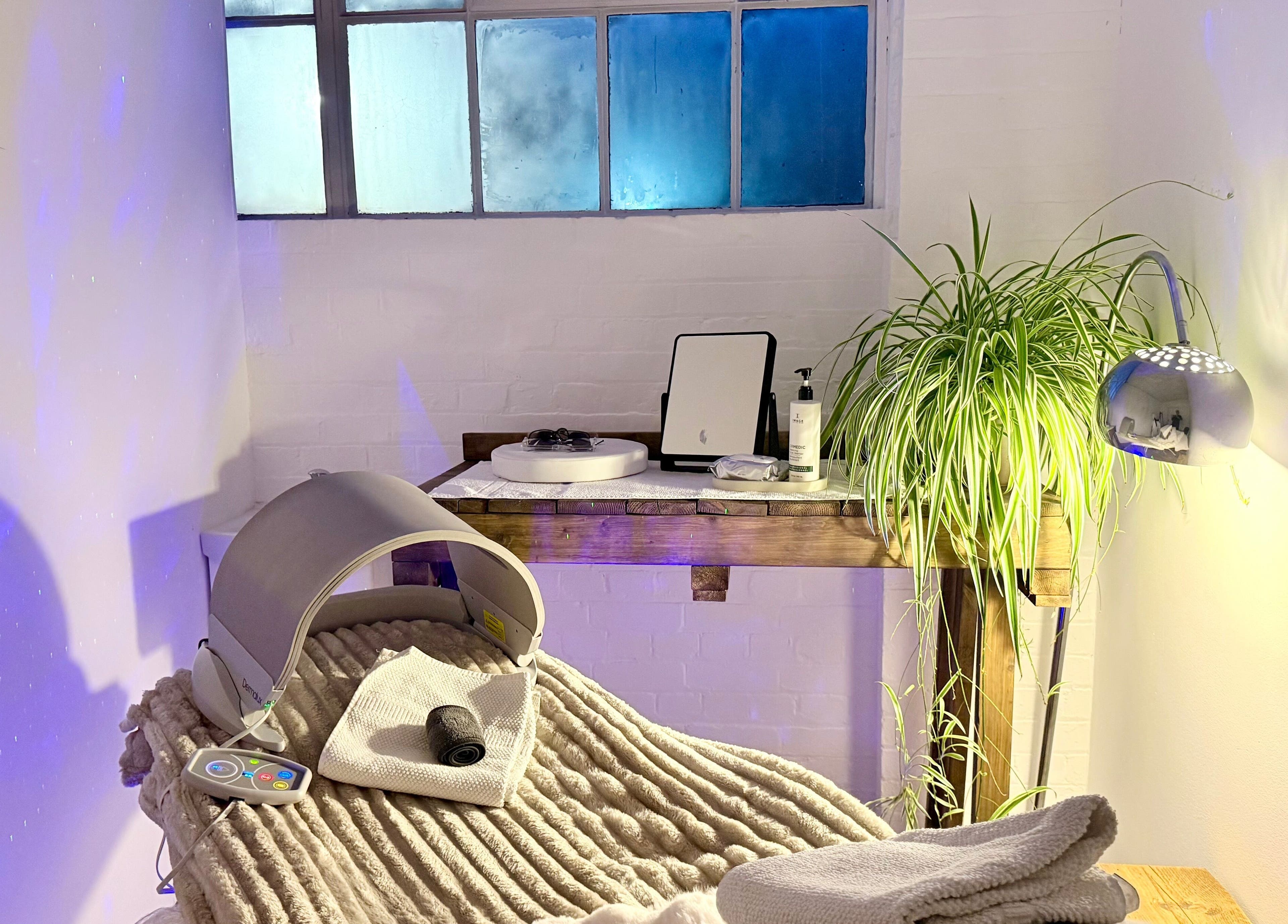 Tranquil wellness room at at1.AESTHETICS, Nottingham, England, GB, featuring plush chair and lush plant.