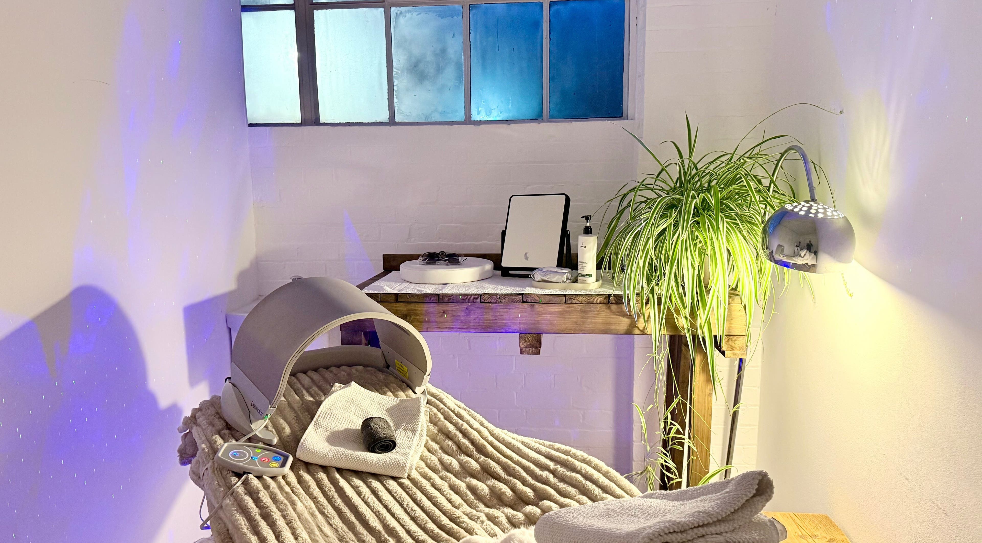 Tranquil wellness room at at1.AESTHETICS, Nottingham, England, GB, featuring plush chair and lush plant.