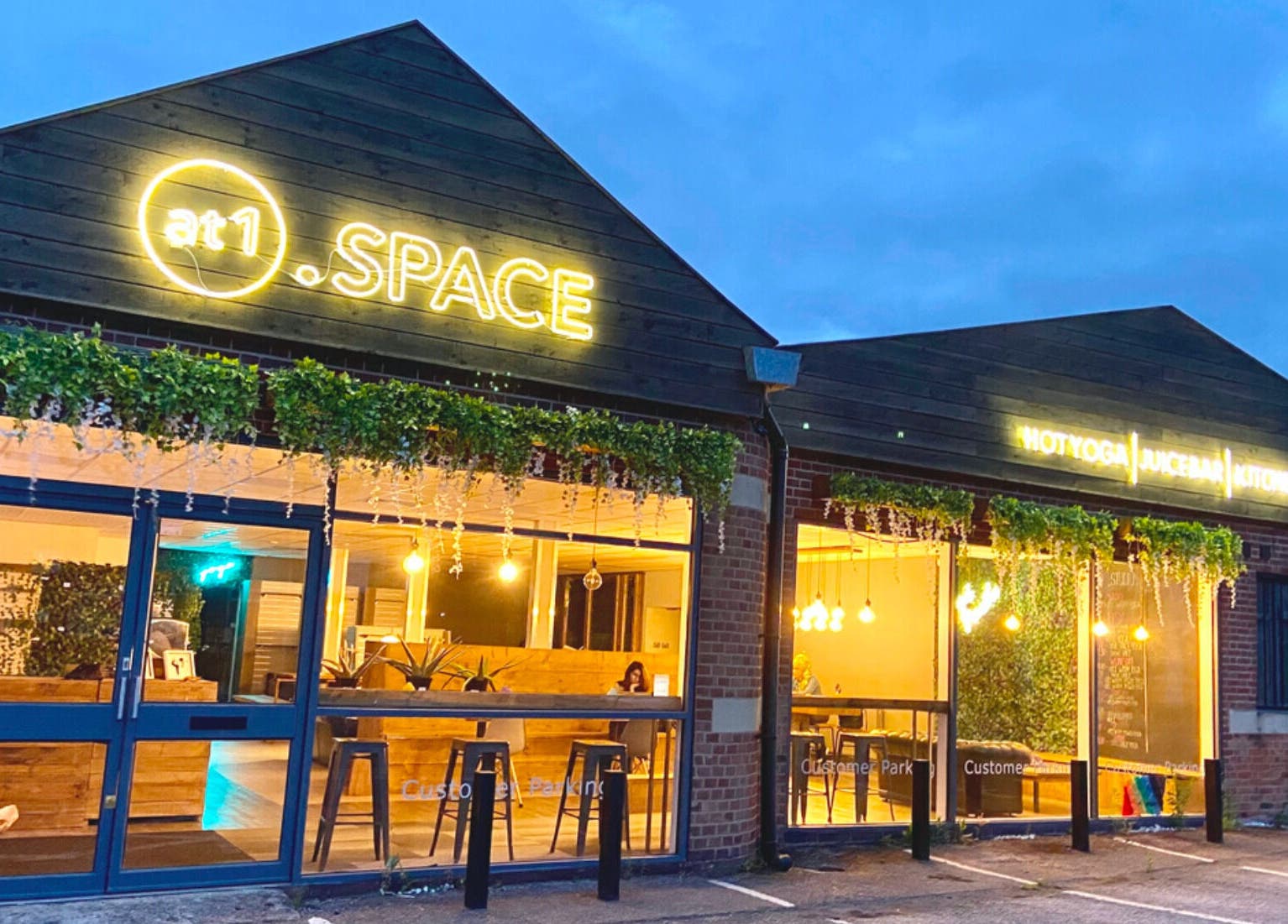 Exterior view of at1.AESTHETICS in Nottingham, England, GB, featuring warm lighting and greenery.