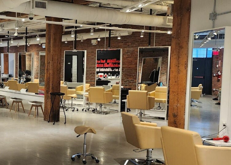 Spacious interior of M Prive Salon in Vancouver, British Columbia, CA, featuring stylish chairs and mirrors.
