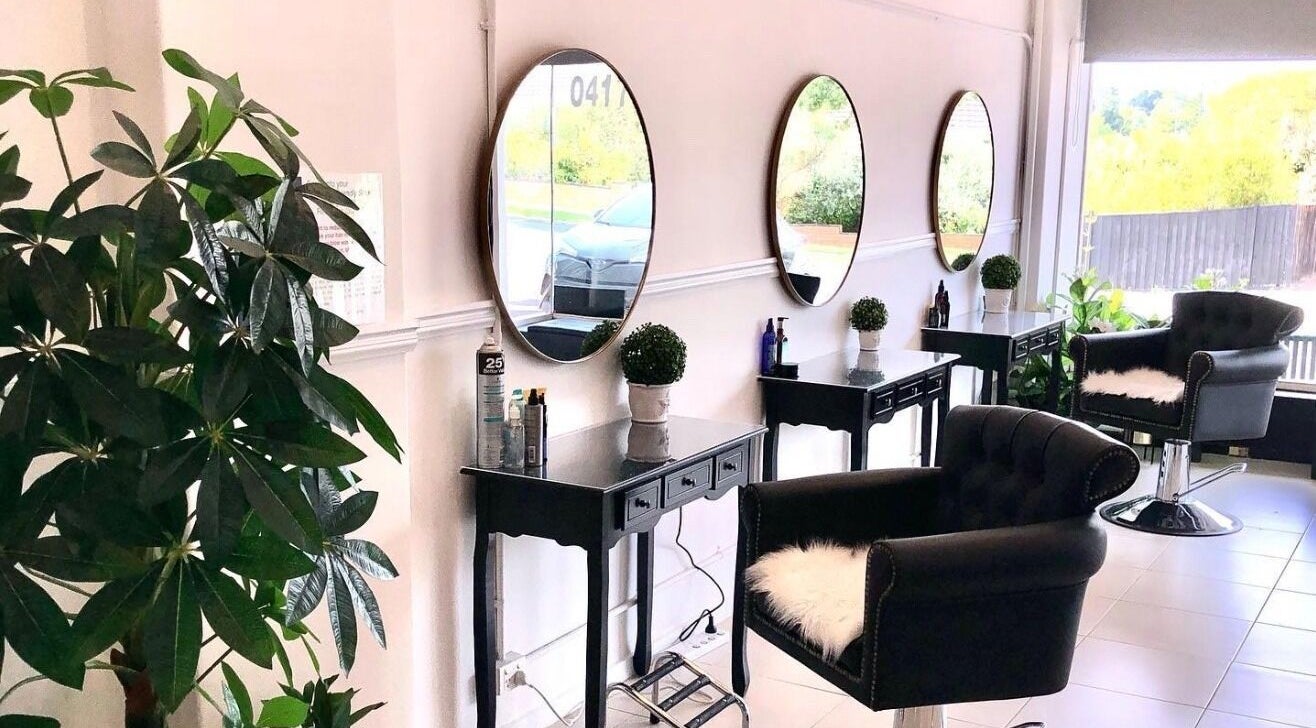 Stylish salon interior at Lolita Hair Exclusive, Melbourne, Victoria, AU, showcasing modern design and lush greenery.