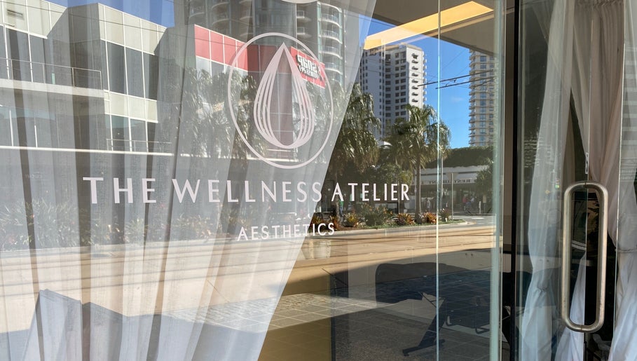 Entrance to The Wellness Atelier in Coolangatta, Queensland, AU, showcasing elegant glass facade.